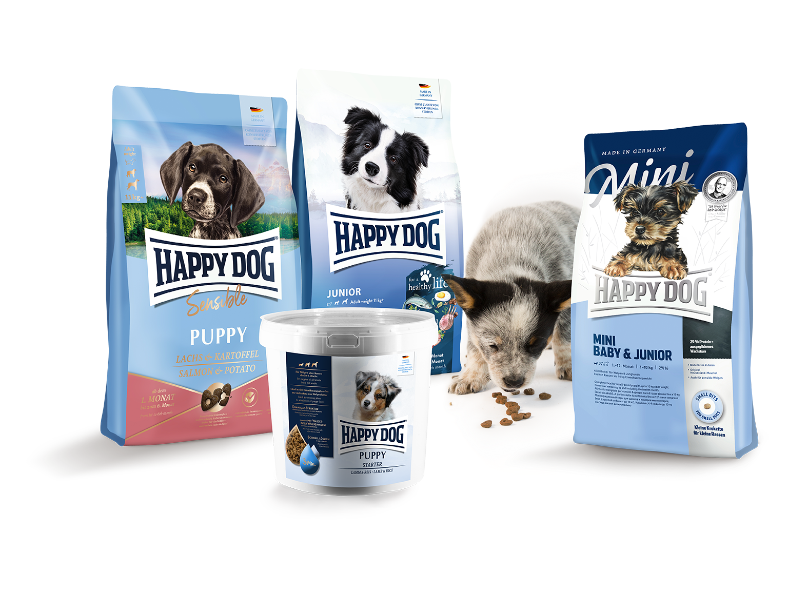 Darstellung von Produkten von Happy Dog der Linie Young. Ein Welpe steht daneben und ist Futter.