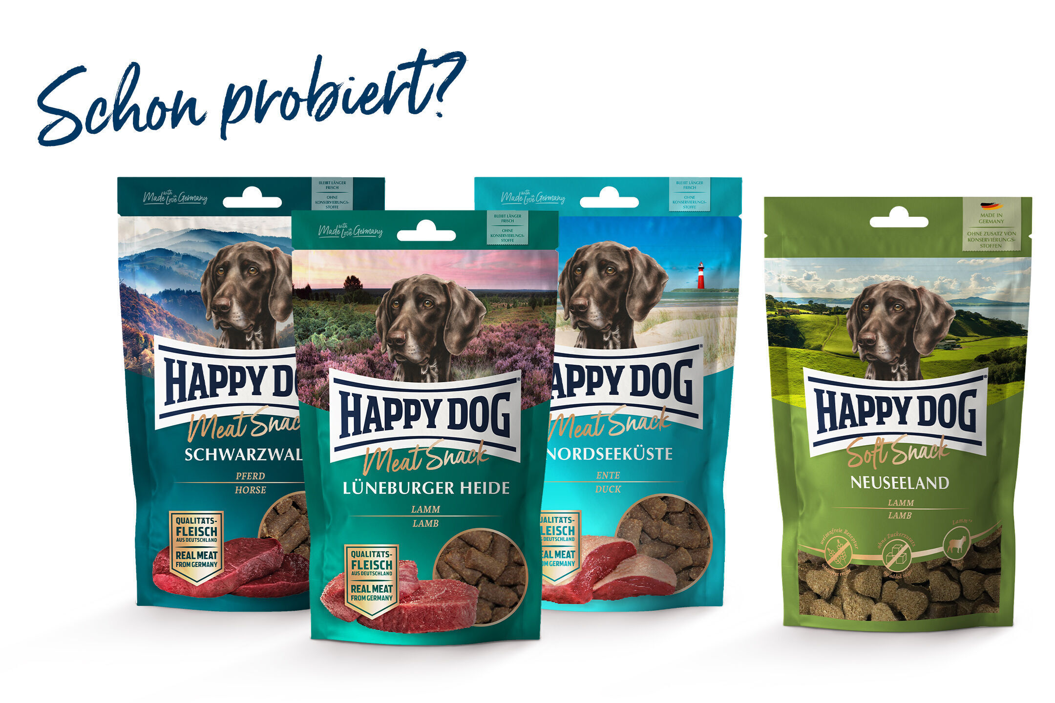 Hundesnacks der Marke Happydog in verschiedenen Sorten, darunter Schwarzwald und Lüneburger Heide, aufgestellt. Aufschrift: "Schon probiert?". Verpackungen mit Landschaftsmotiven und Geschmacksrichtungen.