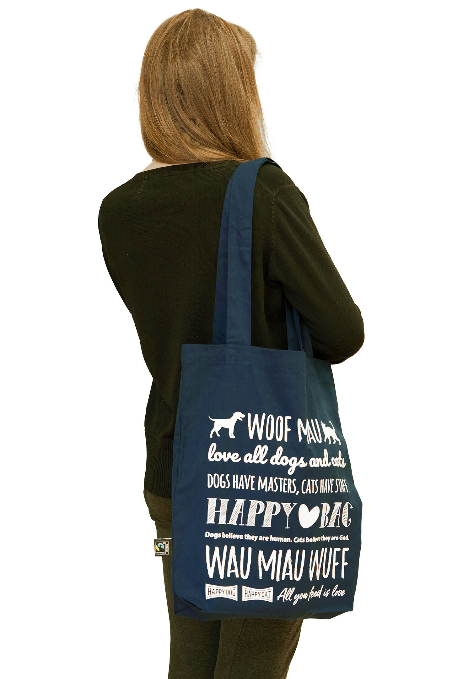 Person trägt eine dunkelblaue Stofftasche mit Tiermotiv und Sprüchen wie „WOOF MAU“, „love all dogs and cats“, „DOGS HAVE MASTERS, CATS HAVE STAFF“, „HAPPY BAG“.