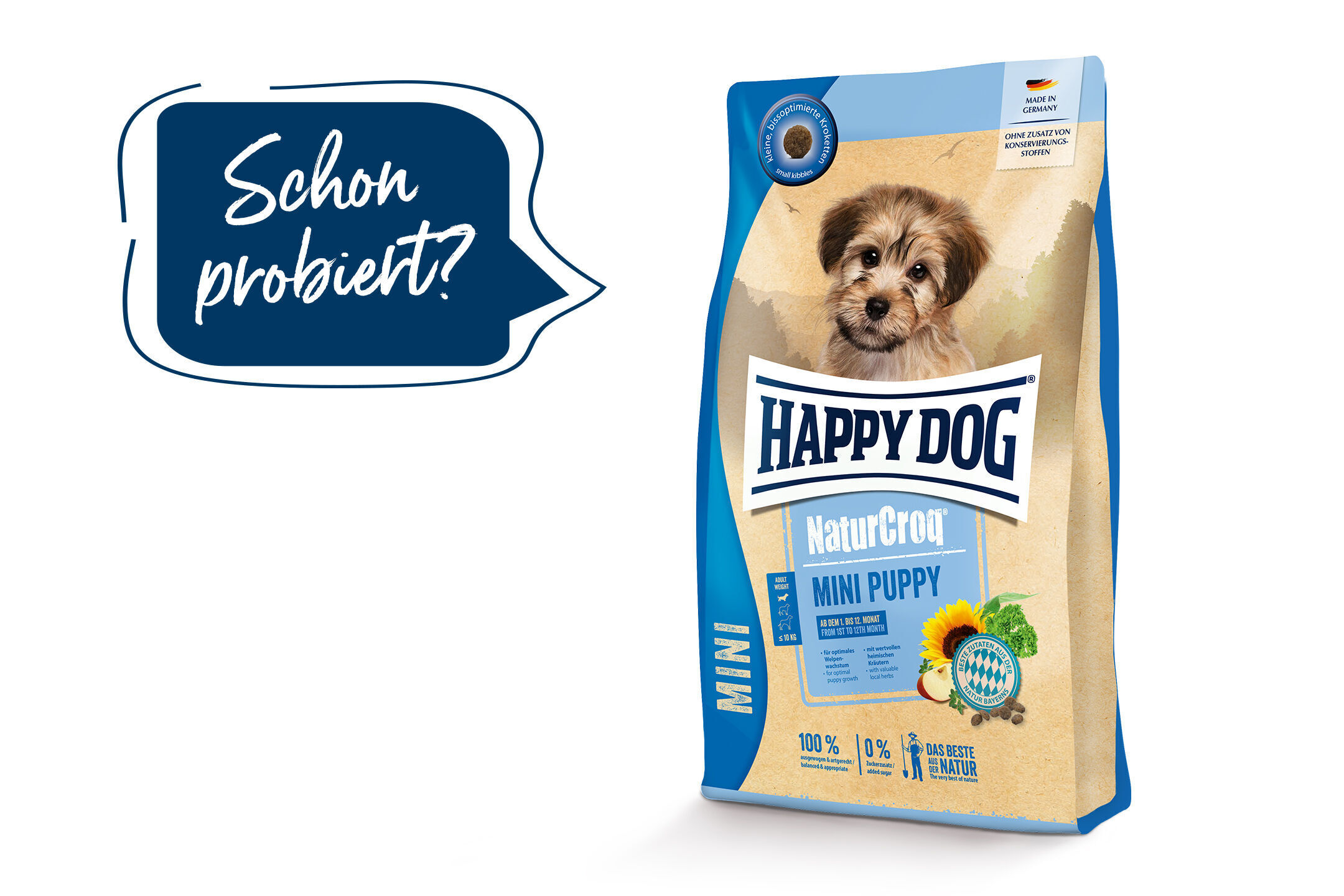 Happydog Verpackung mit Welpenfoto und Schriftzug "NaturCroq Mini Puppy". Text in einer Sprechblase: "Schon probiert?". Aufschrift "Made in Germany" und ohne Zusatz von Konservierungsstoffen.