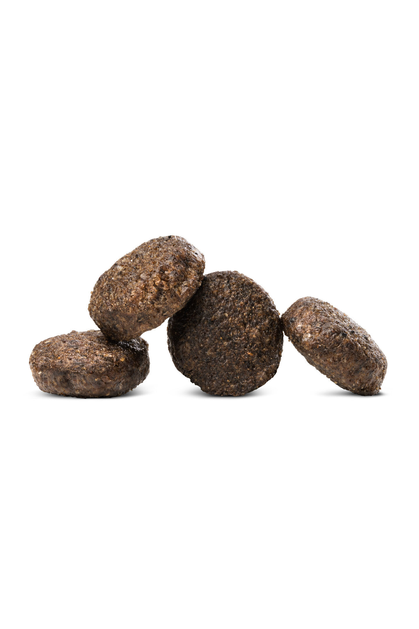 Vier runde, braune Kroketten formen eine schräge Stapelung auf weißem Hintergrund, die Textur scheint fest und körnig. Happydog Produkt.
