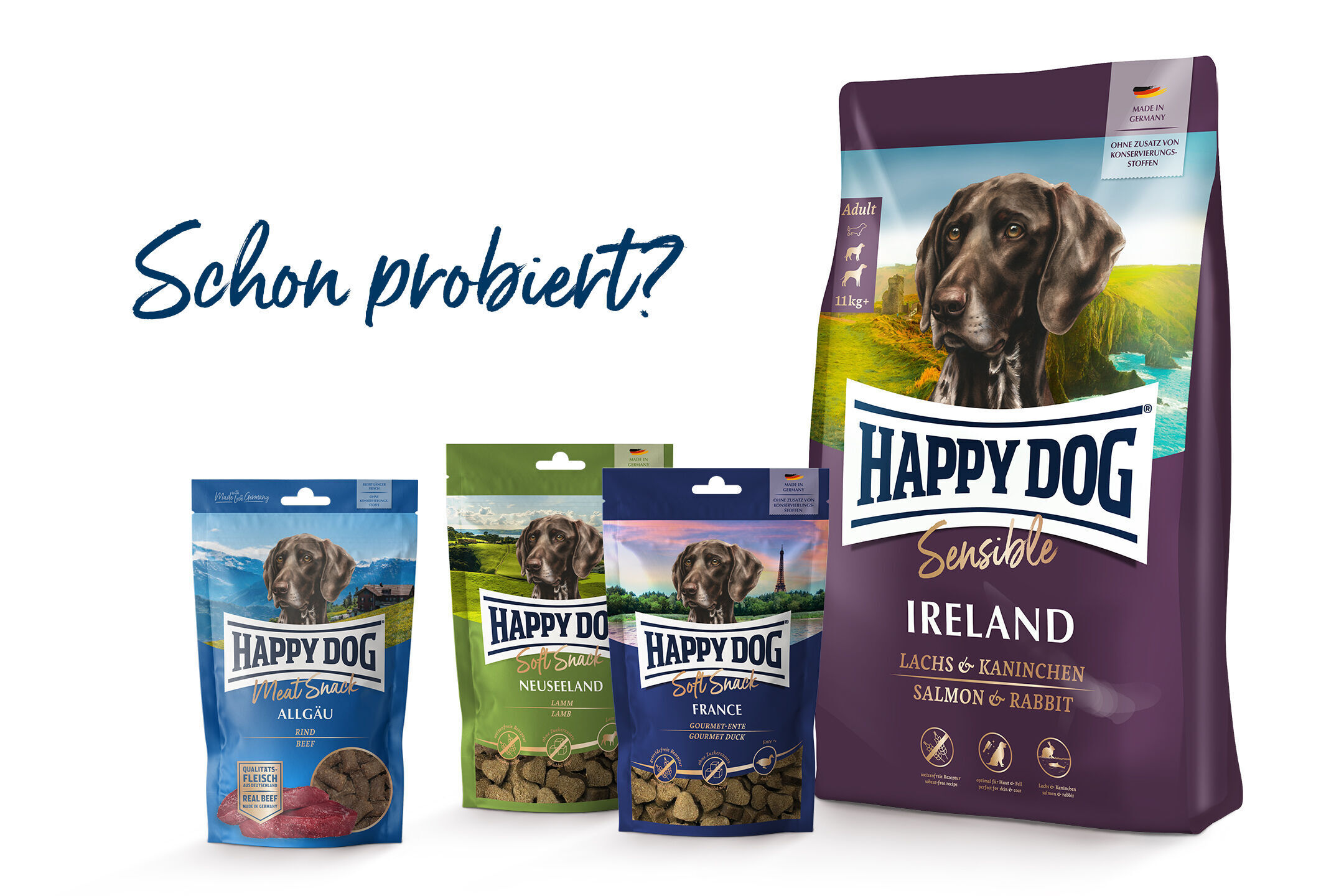Hundesnacks und Futter in verschiedenen Verpackungen mit der Marke "Happy Dog". Text: "Schon probiert?" Verpackungen zeigen Hundebilder und Landschaften.
