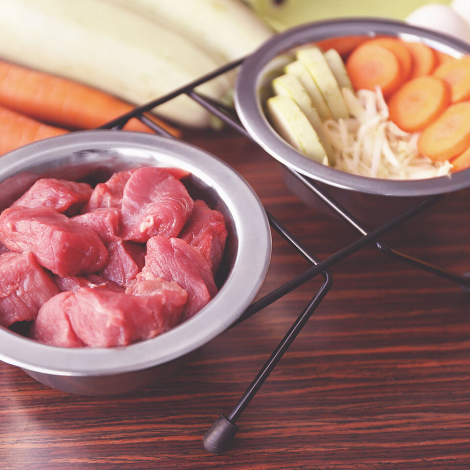 Zwei Schalen mit Fleisch und Gemüse auf dem Tisch.