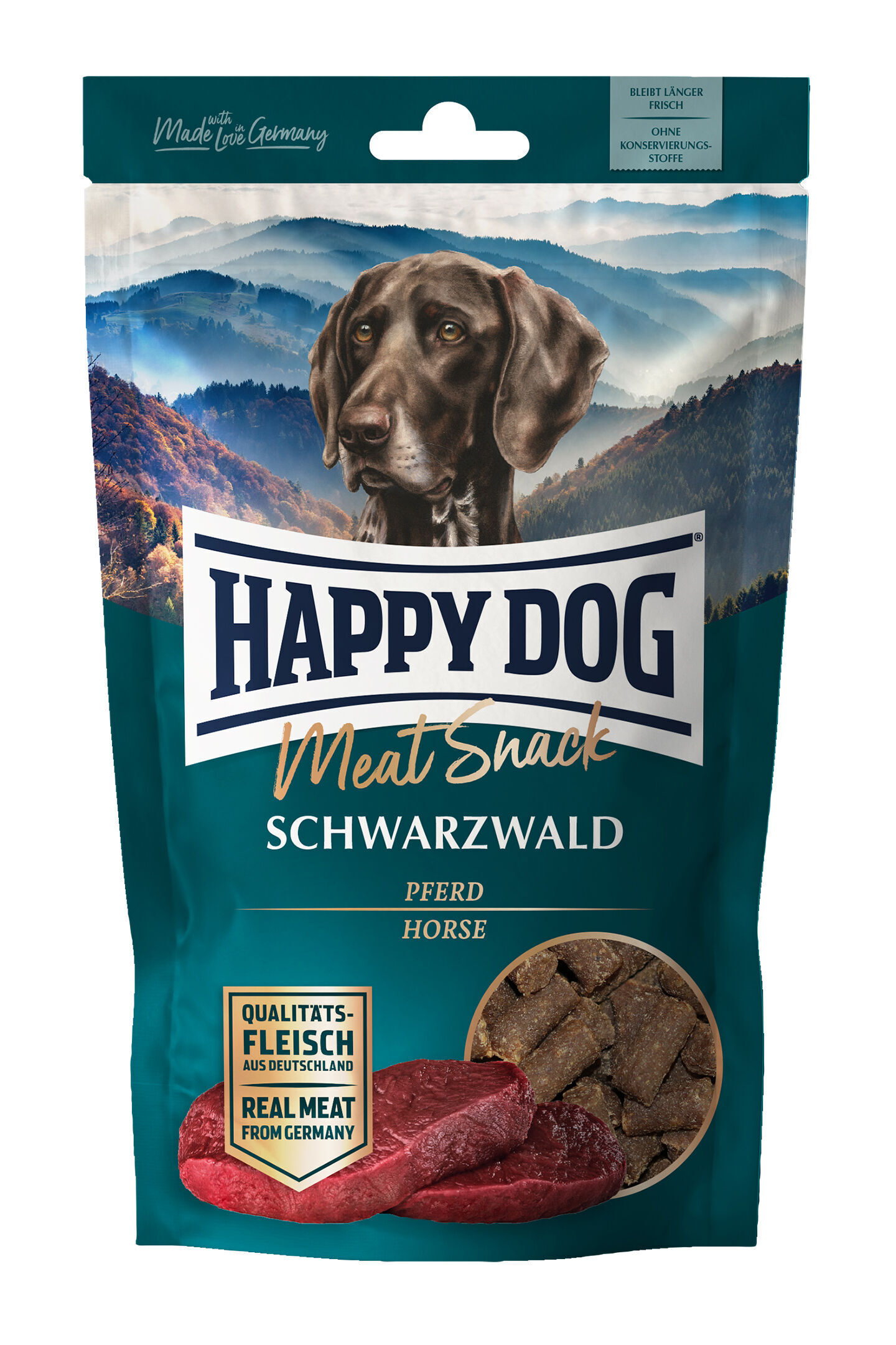 Hundesnack-Tüte mit Aufdruck "Happy Dog Meat Snack Schwarzwald Pferd". Tüte zeigt Hundekopf, Berge im Hintergrund und Fleischstücke, betont Qualität aus Deutschland.
