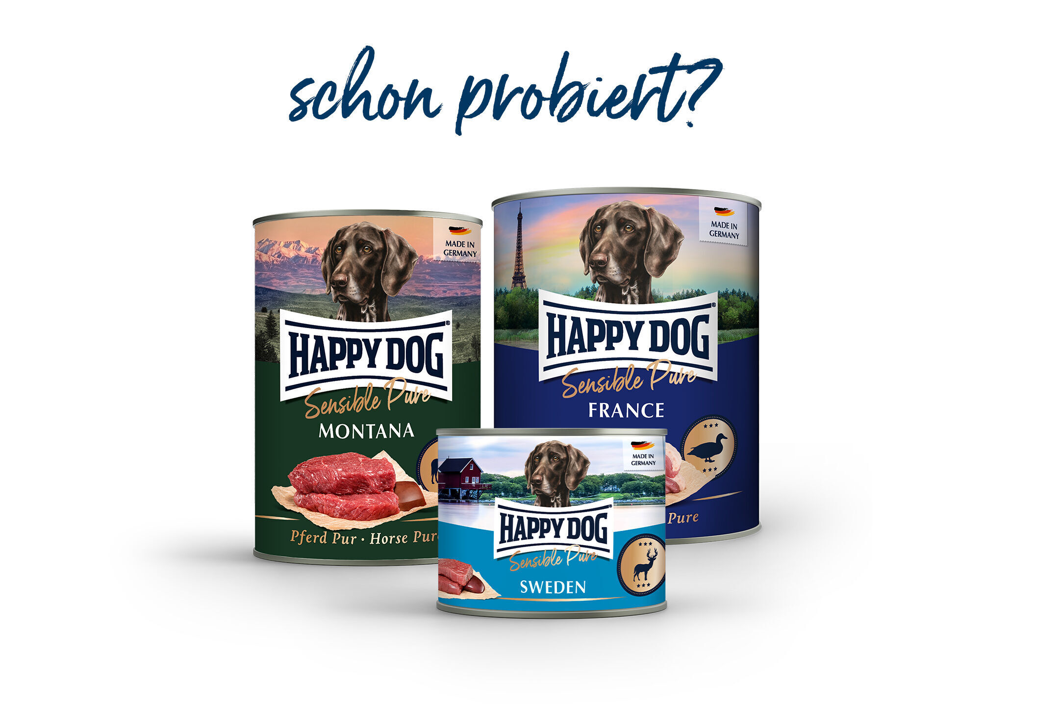 Drei Dosen Hundefutter der Marke Happydog mit verschiedenen Geschmacksrichtungen (Montana, France, Sweden) sind nebeneinander abgebildet. Oben steht der Text: "schon probiert?".