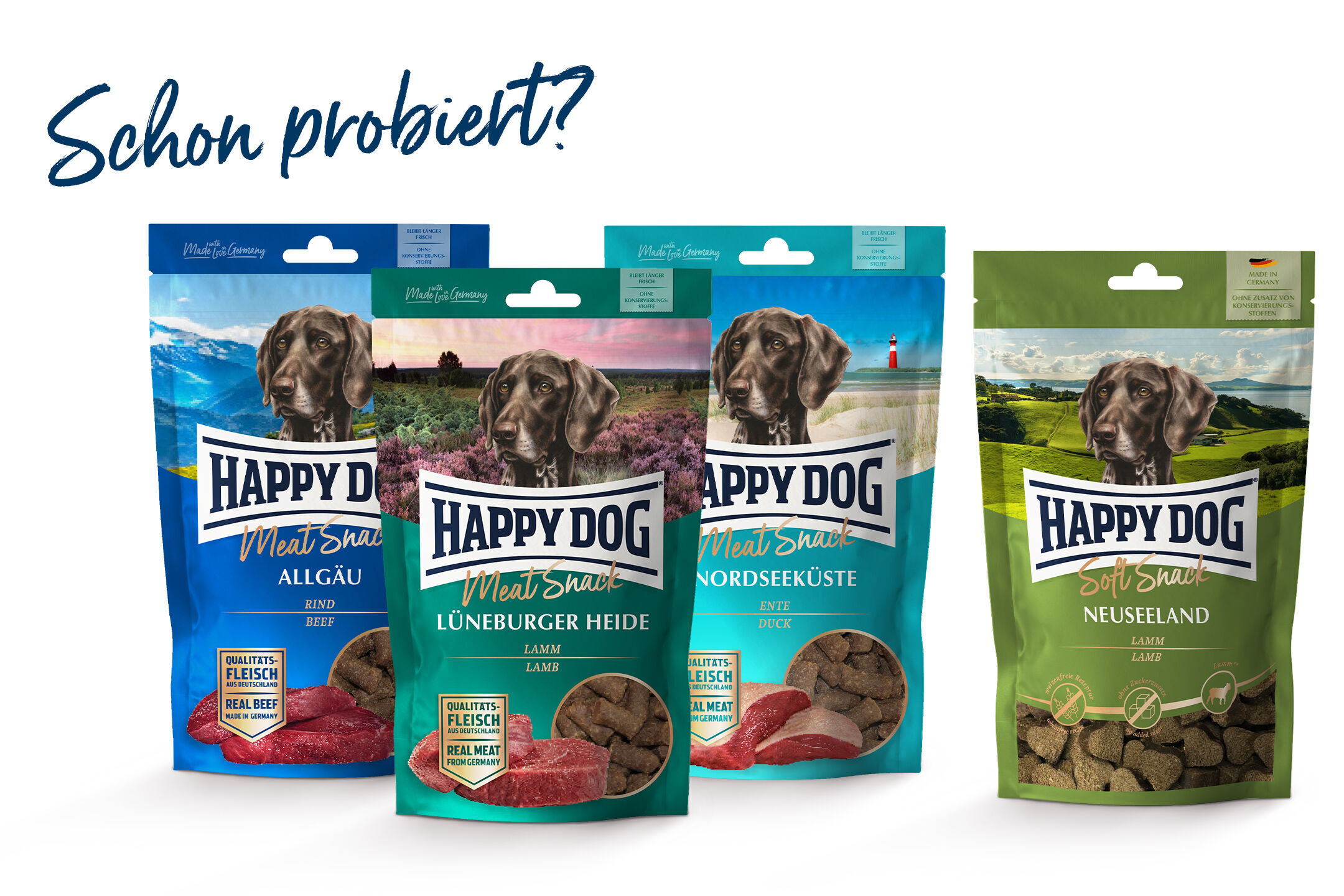 Vier Happy Dog Futtersnack-Verpackungen mit verschiedenen Geschmacksrichtungen: Allgäu, Lüneburger Heide, Nordseeküste, Neuseeland; darüber der Text „Schon probiert?“