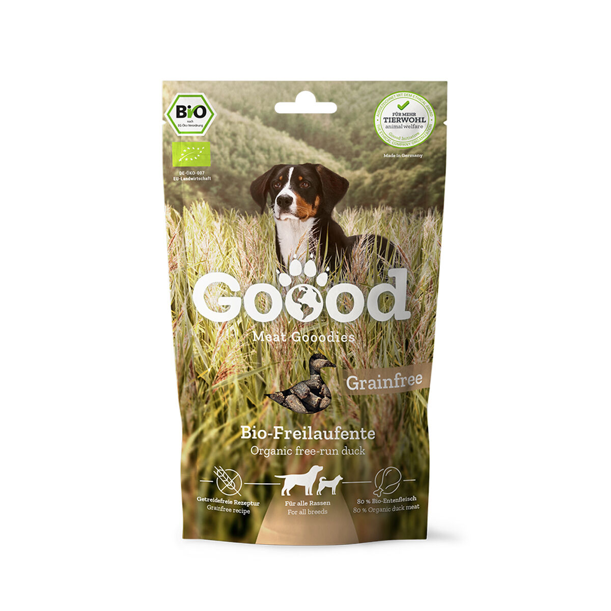 Verpackung für Hundesnacks mit der Aufschrift „Goood Meat Goodies“, „Bio-Freilaufente“, „Grainfree“. Ein Hund auf einem Feld. Bio-Siegel und Tierwohllabel sichtbar.