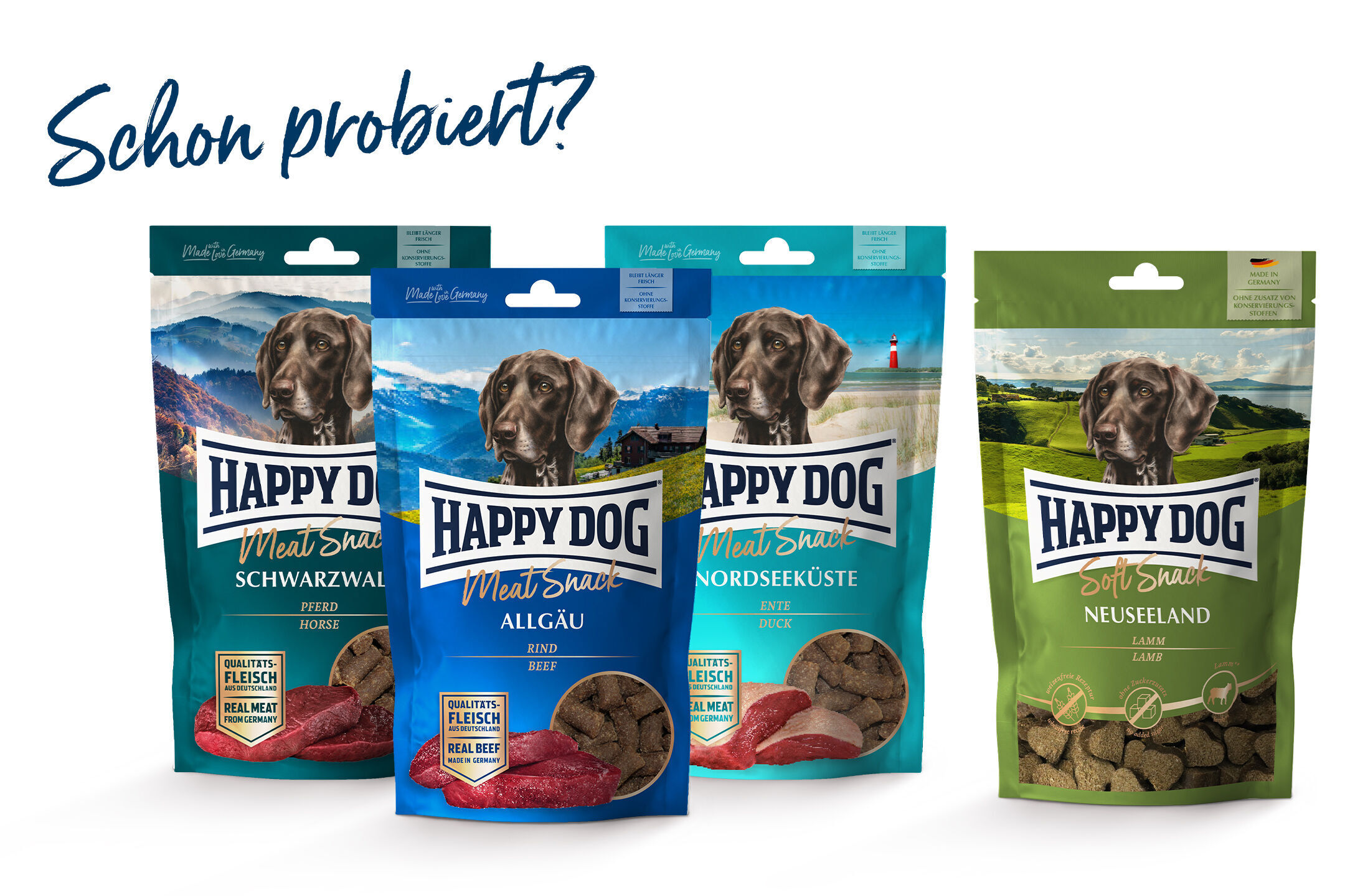 Vier Verpackungen „Happydog“-Hundesnacks mit Landschaftshintergründen und Hundeabbildungen; Geschmacksrichtungen: Schwarzwald, Allgäu, Nordseeküste, Neuseeland. Text: "Schon probiert?"