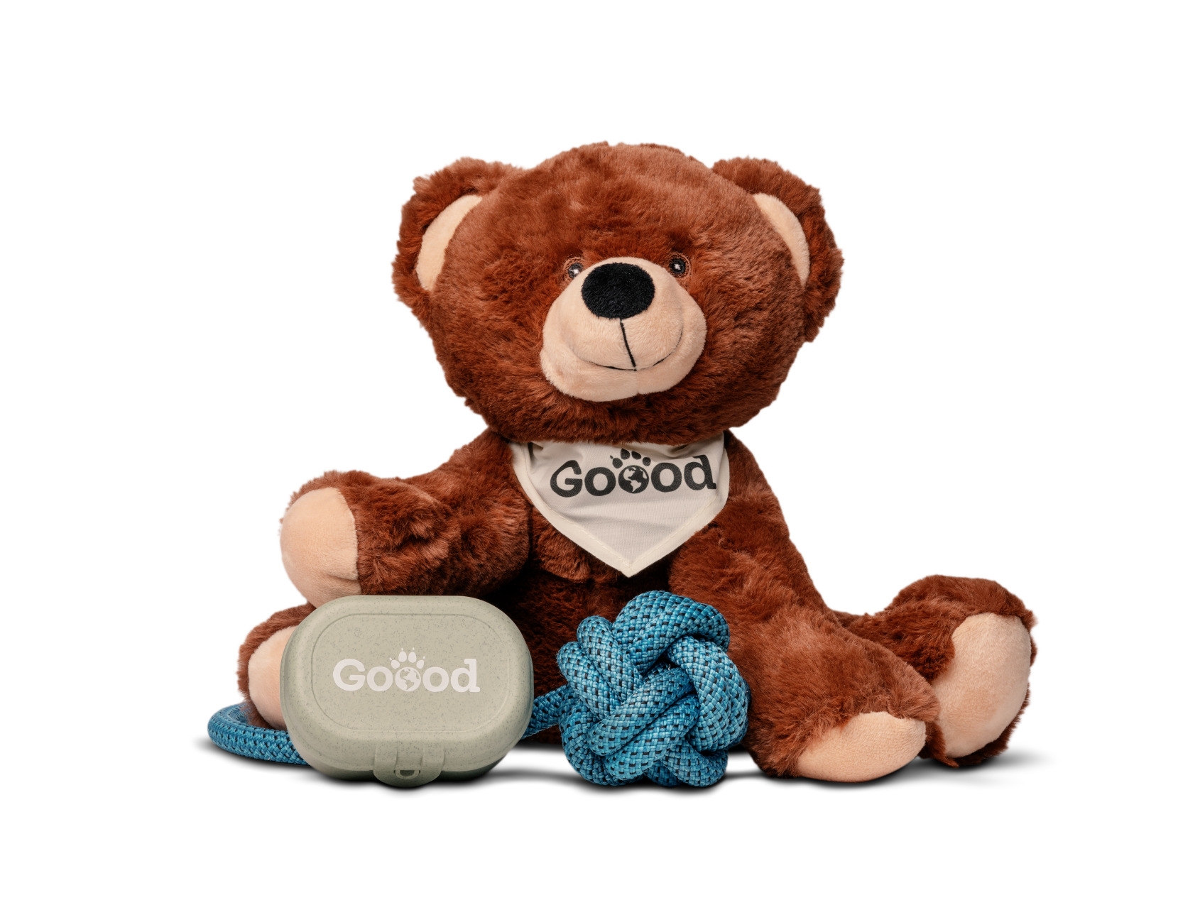 Ein Teddybär-Kuscheltier für Hunde sitzt am Boden. Vor ihm liegt ein Schleuderball und eine Leckerlibox der Marke Goood.