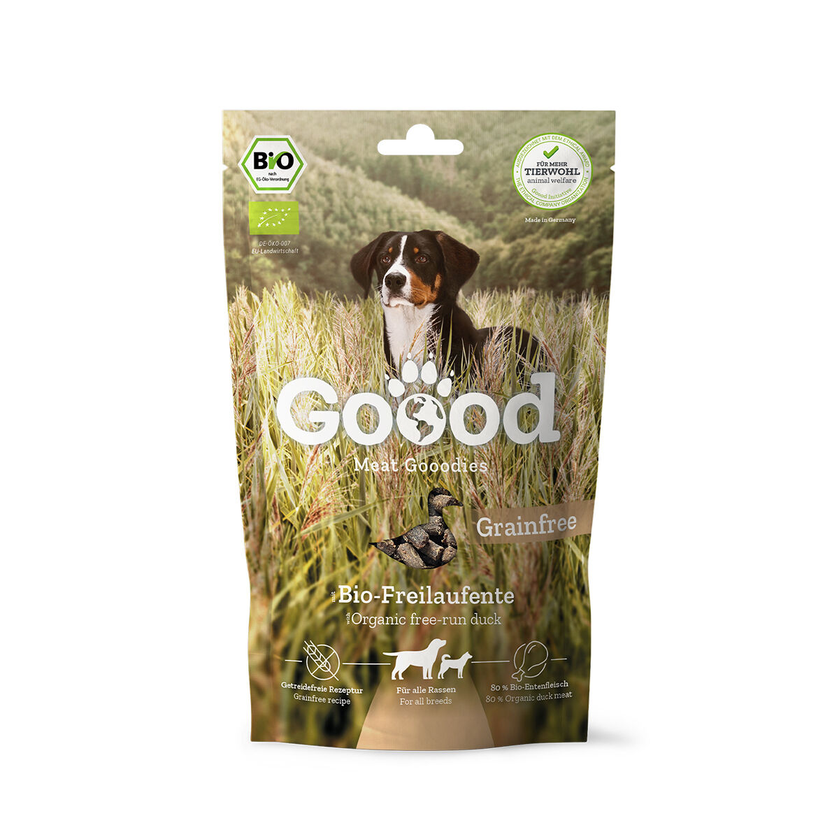 Verpackung für Hundesnacks mit der Aufschrift „Goood Meat Goodies“, „Bio-Freilaufente“, „Grainfree“. Ein Hund auf einem Feld. Bio-Siegel und Tierwohllabel sichtbar.