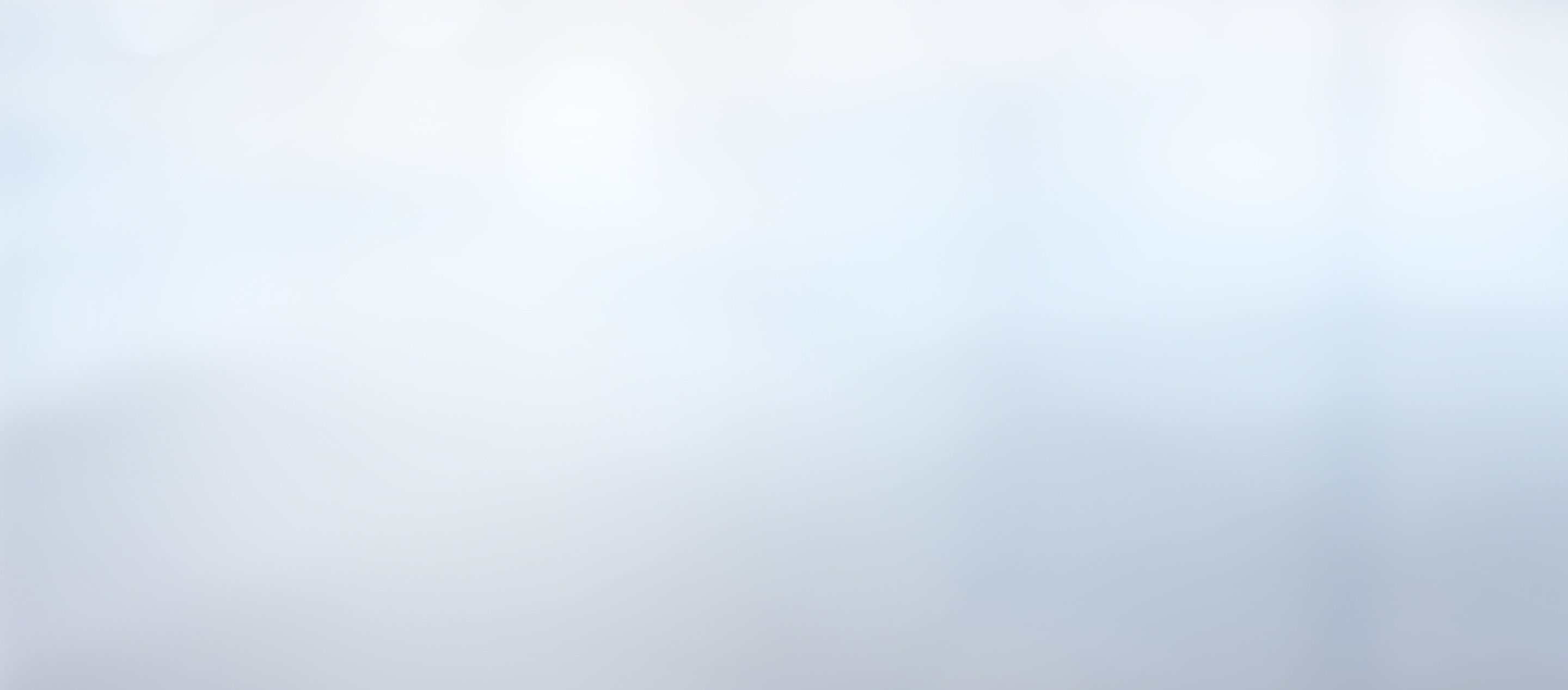 Unschärfeeffekt ohne erkennbare Objekte. Das Bild zeigt eine gleichmäßige weiße Fläche mit leichten blauen und grauen Verläufen, die eine ruhige Atmosphäre erzeugen.
