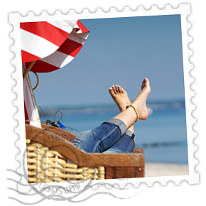 Briefmarke einer  Frau in einem Strandkorb am Meer liegend.
