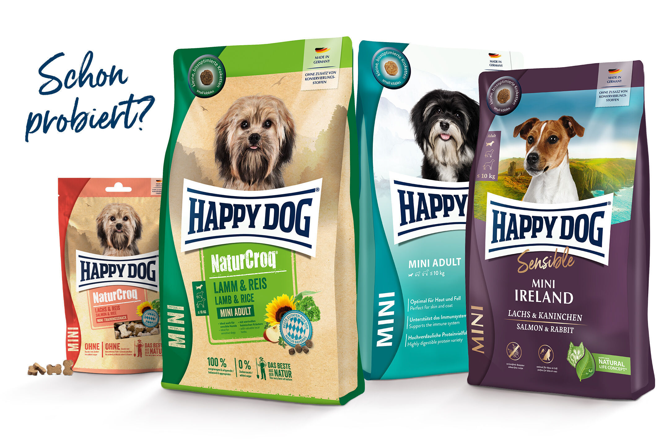 Futtermittel-Verpackungen mit Hundeabbildungen und der Aufschrift "HAPPY DOG" in verschiedenen Sorten. Text: "Schon probiert?" Links Verpackungen mit "Lamm & Reis", "Lachs & Kaninchen".