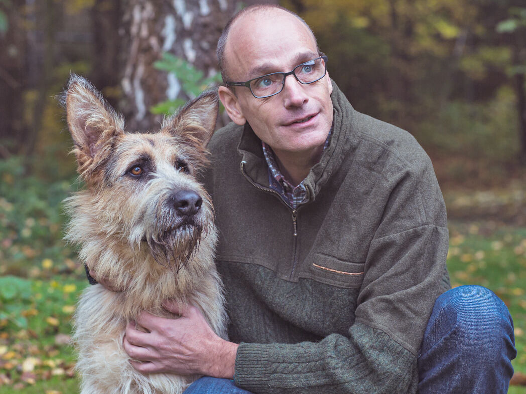 Geschäftsführer Georg Müller mit einem Tierschutzhund im Grünen