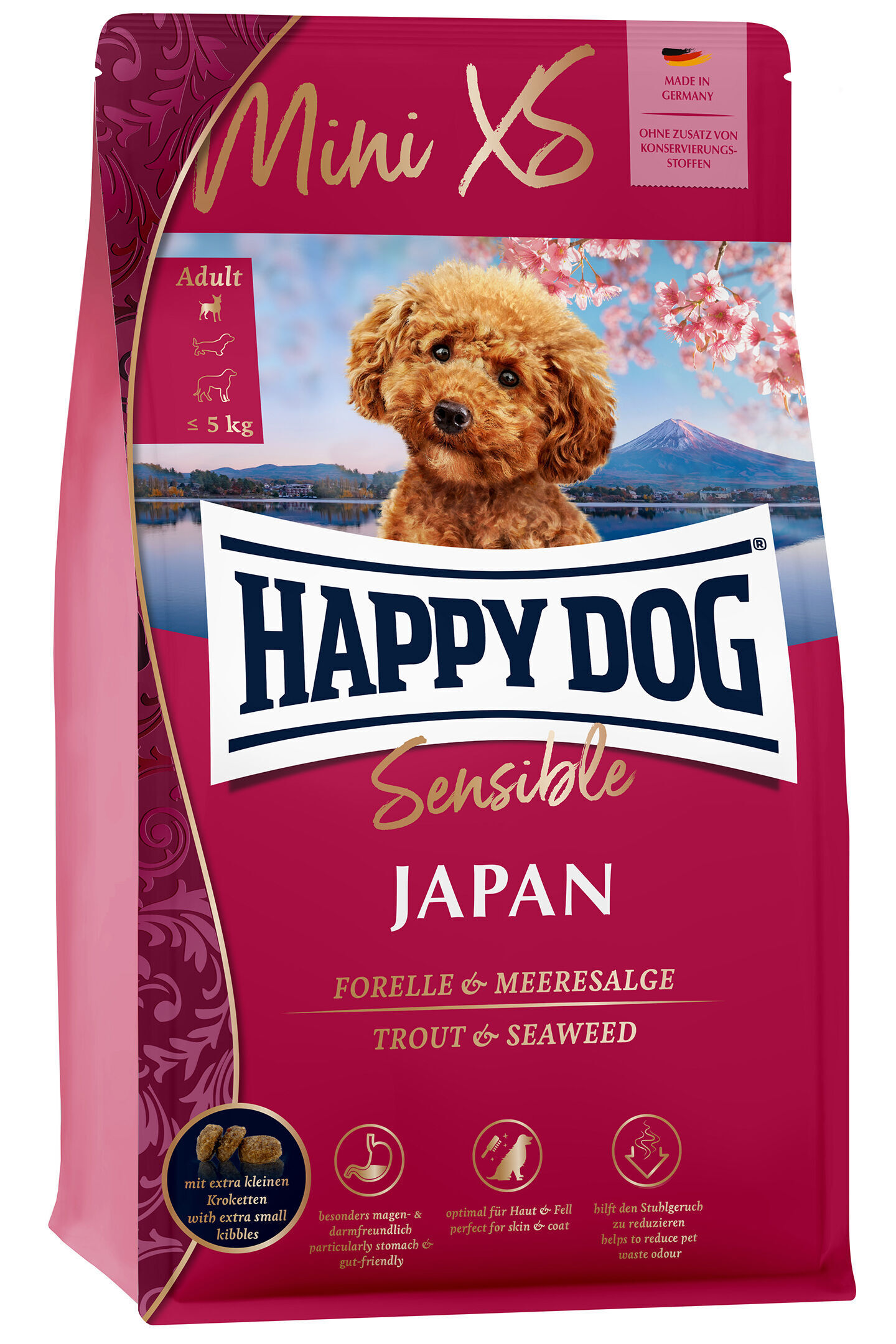 Verpackung mit Happy Dog Mini XS Hundefutter, Geschmacksrichtung Japan, zeigt einen kleinen, lockigen Hund vor japanischer Landschaft. Beschriftungen: "Made in Germany" und "ohne Zusatz von Konservierungsstoffen".