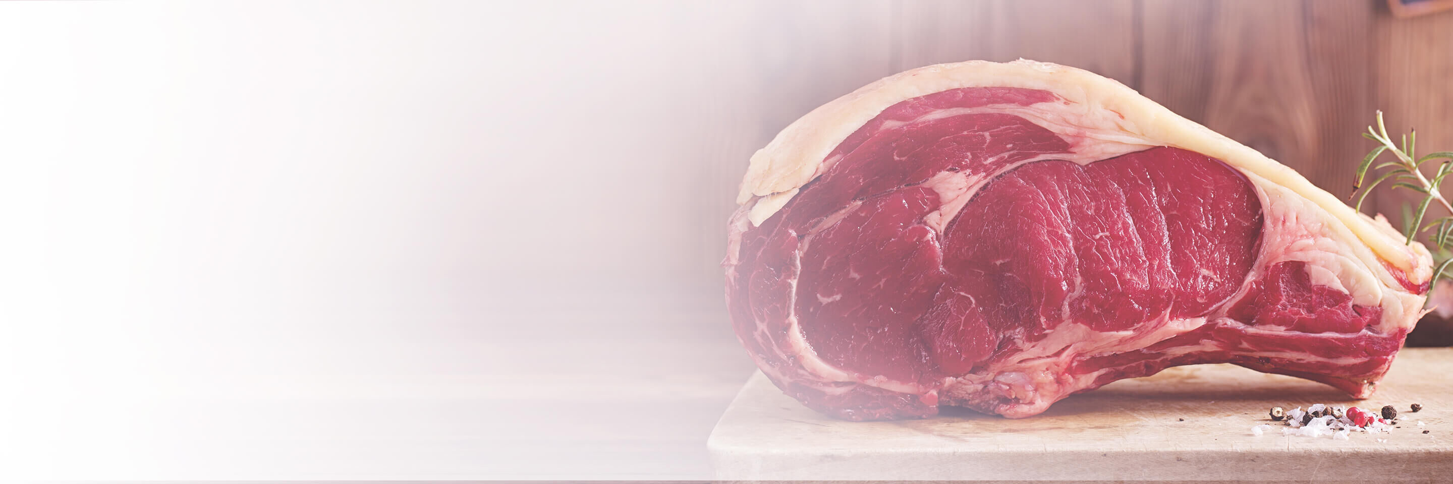 Ein rohes Stück Fleisch liegt auf einem Holzbrett