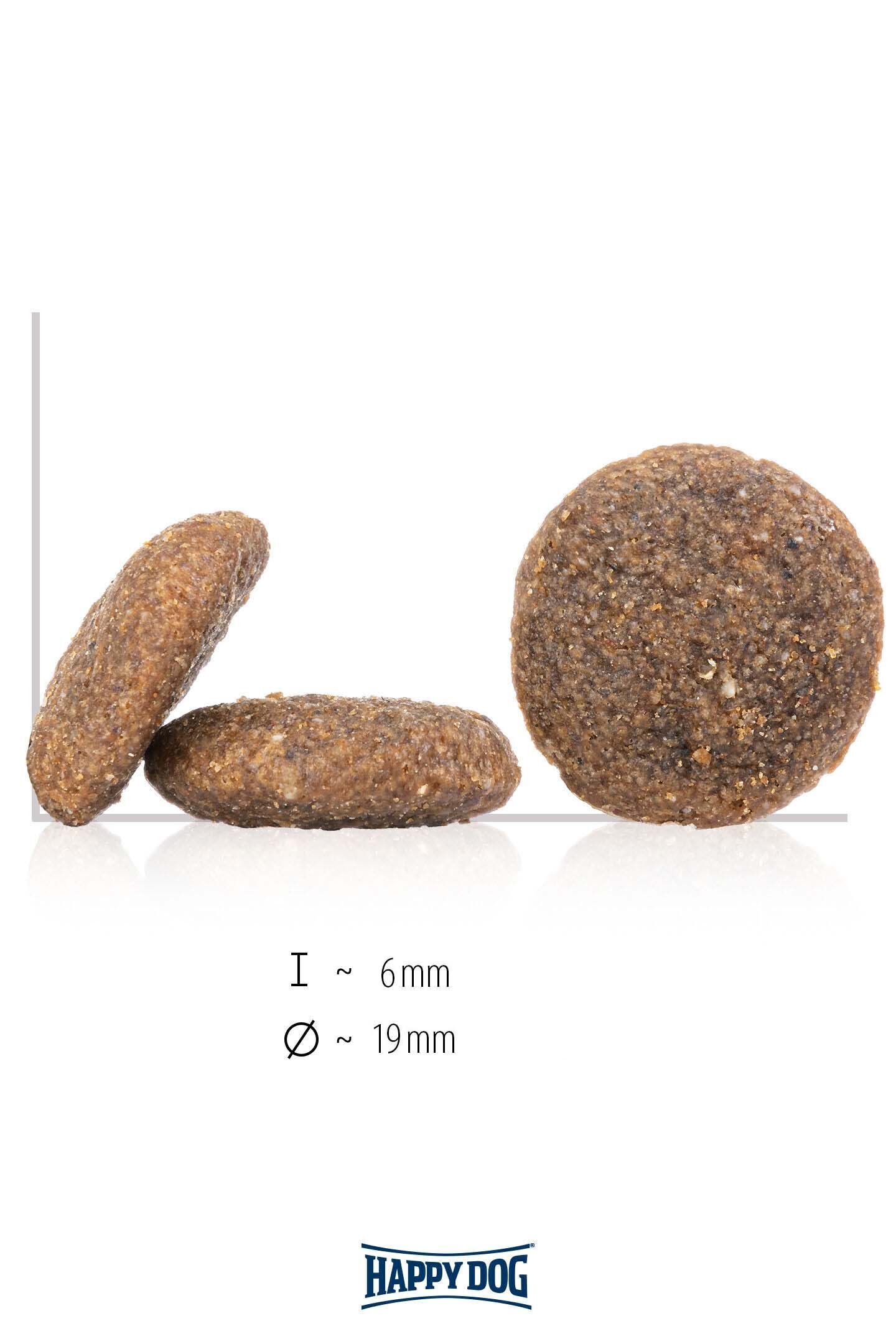 Drei braune, runde Happydog-Kroketten in Seiten- und Frontalansicht. Text: „l ~ 6mm, Ø ~ 19mm“. Weiße Hintergrundfläche.