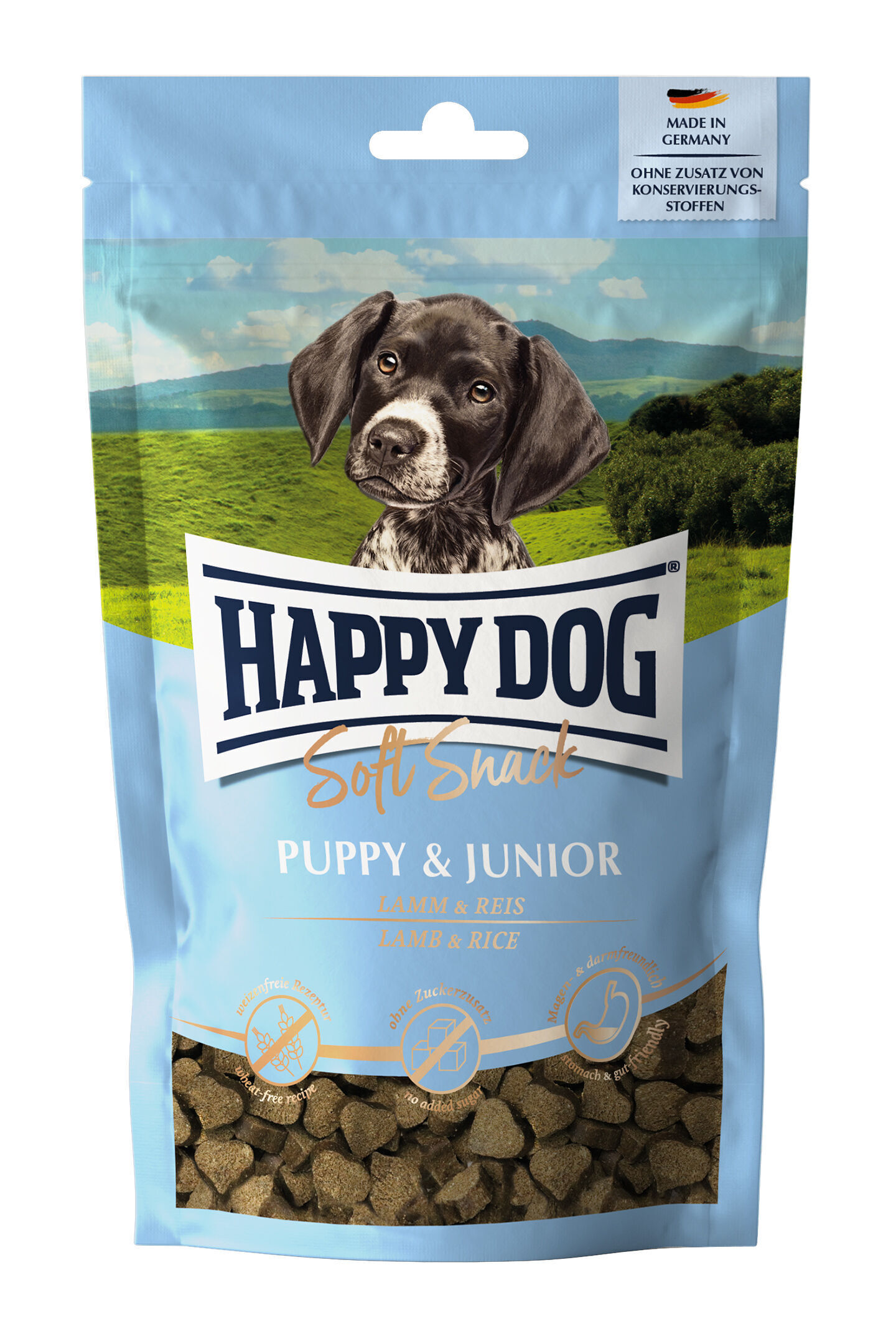 Soft Snack Puppy & Junior Verpackung für Happydog Soft Snack, Puppy & Junior Lamm & Reis. Zeigt Hundebild, Berge im Hintergrund. Text: „Made in Germany, ohne Zusatz von Konservierungsstoffen“. Enthält herzförmige Snacks.