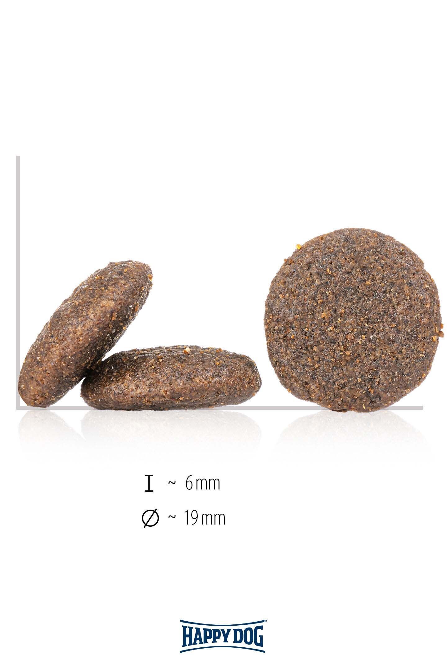 Runde, braune Hundetrockenfutterstückchen von Happy Dog; zwei sind aufgerichtet und lehnen an einem liegenden. Maße: 6 mm Dicke, 19 mm Durchmesser.