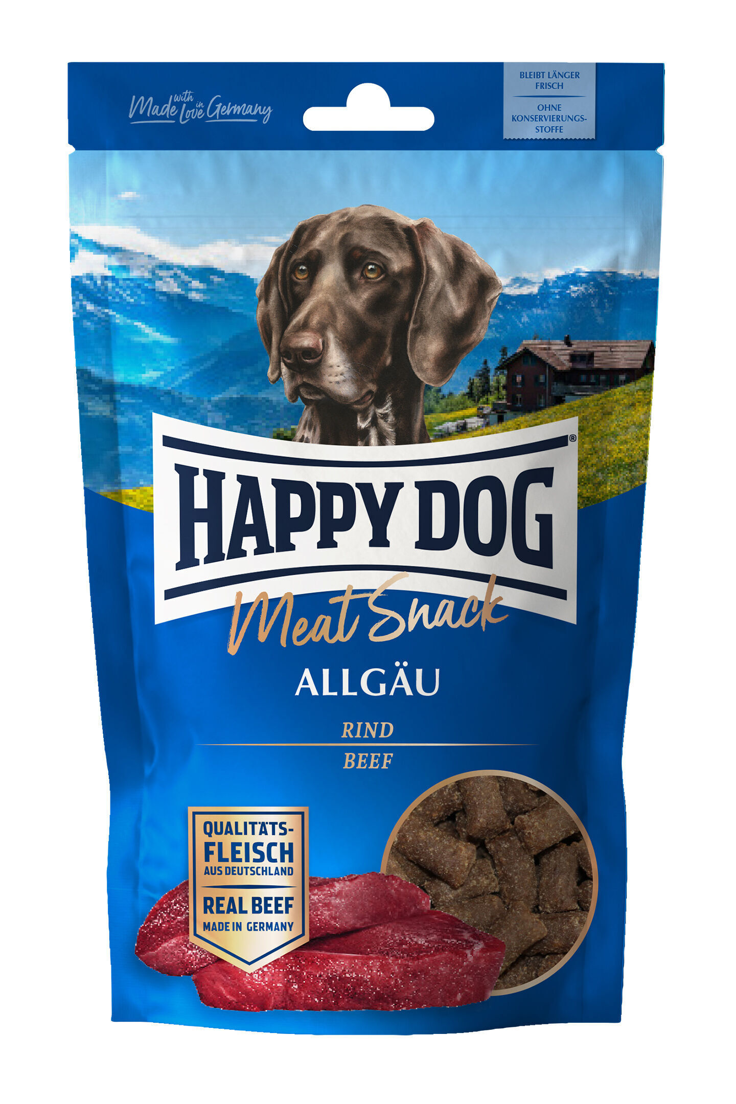 Eine Verpackung von „Happy Dog Meat Snack Allgäu“ zeigt einen Hund vor Berglandschaft. Text: „Rind“, „Qualitätsfleisch aus Deutschland“, „Ohne Konservierungsstoffe“, „Made with Love in Germany“.
