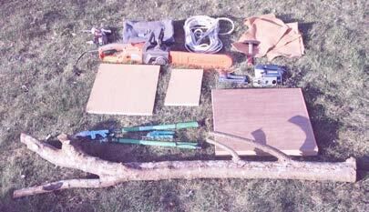 Materialien für den Bau eines Kratzbaums liegen auf einer Wiese.