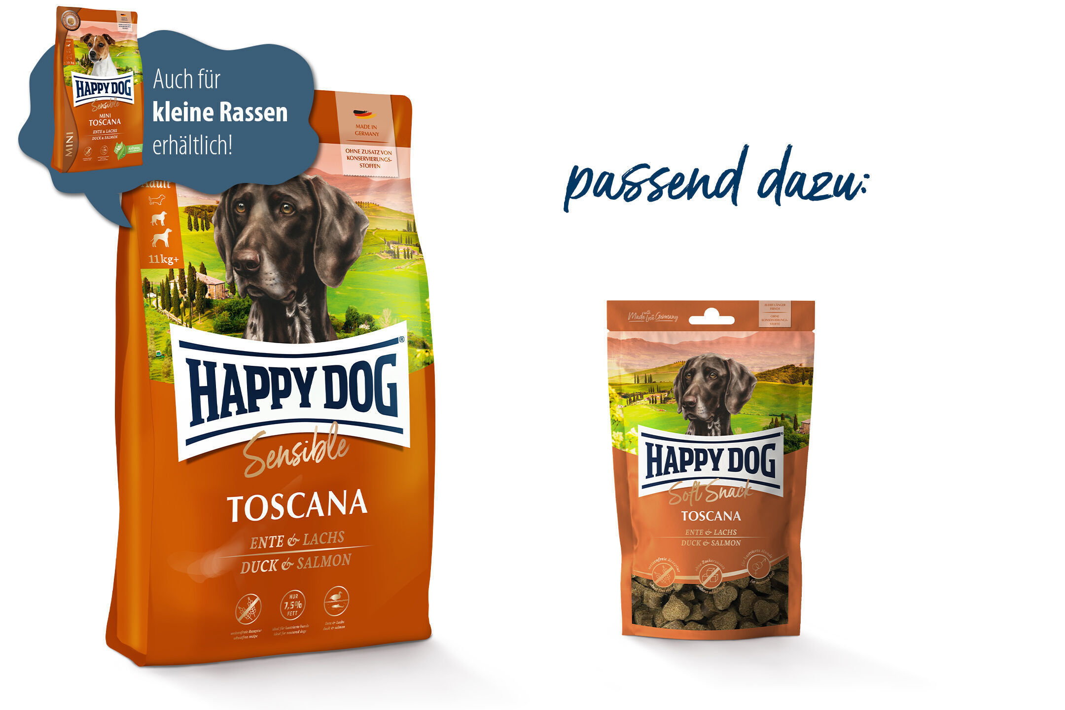 Hundefuttertüten der Marke Happydog in orange und braun mit einem Hundebild, label „Sensible Toscana Ente & Lachs“. Sprechblase: „Auch für kleine Rassen erhältlich!“. Made in Germany.