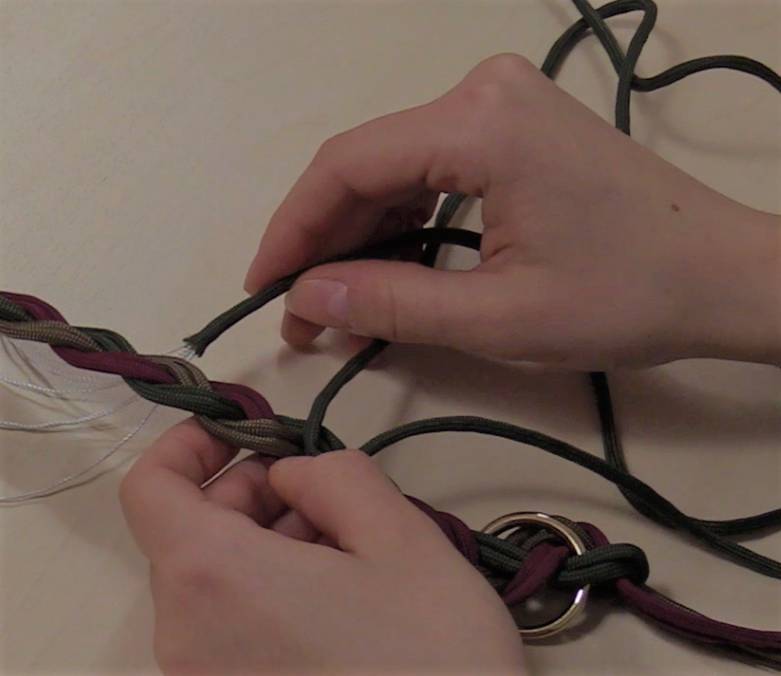 Es sind Hände zu sehen, welche ein Hundehalsband flechten.