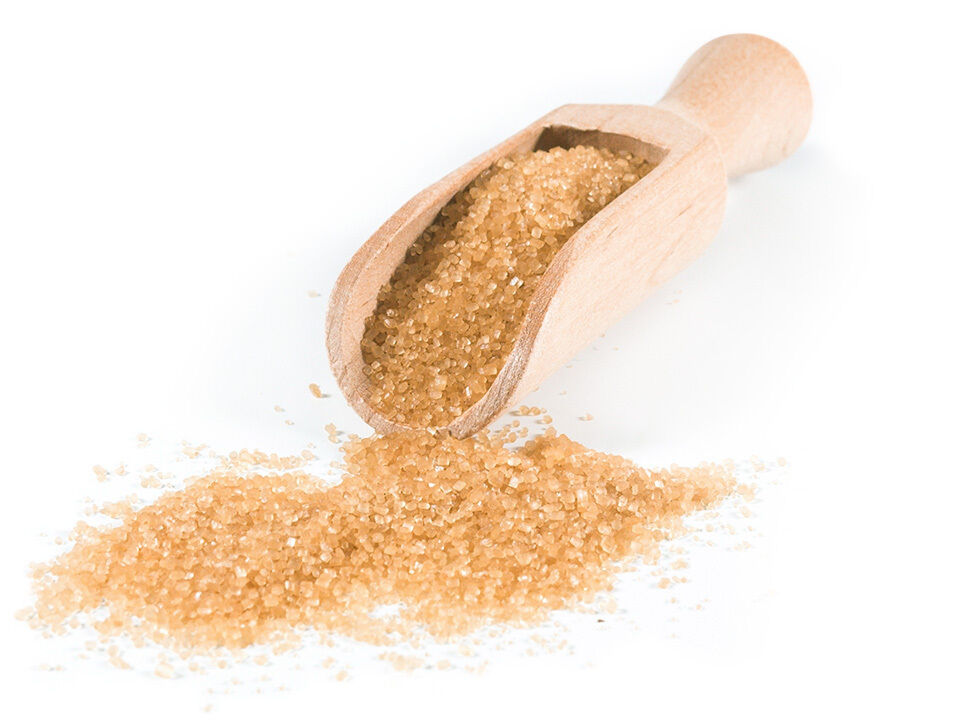 Kleine Holzschaufel gefüllt mit braunem Zucker