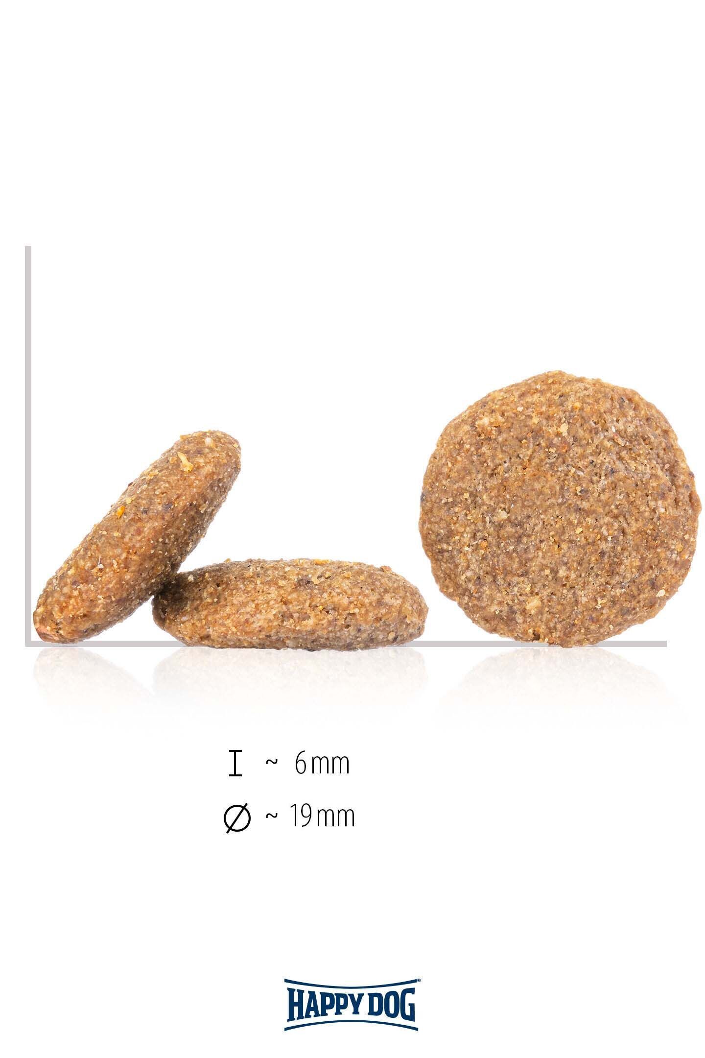 Drei runde, bräunliche Pellets sind aufrecht stehend zu sehen. Text: „l ~ 6mm, ø ~ 19mm“. Marke: Happydog.